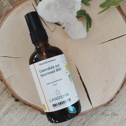 Flacon d’huile de calendula bio posé sur une table en bois avec fleurs séchées – soin naturel apaisant