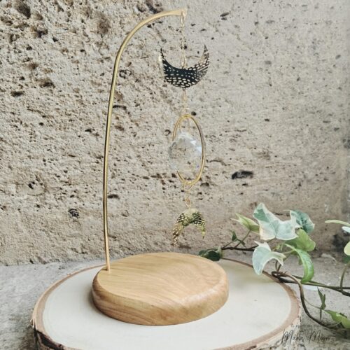 Attrape-soleil Luna à poser avec Triple Lune en laiton, cristal facetté et socle en bois. Objet Feng Shui pour harmoniser l’énergie et décorer l’intérieur.