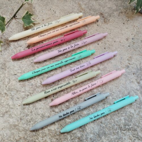 Stylo à bille avec message positif au choix et encre noire, couleur aléatoire.